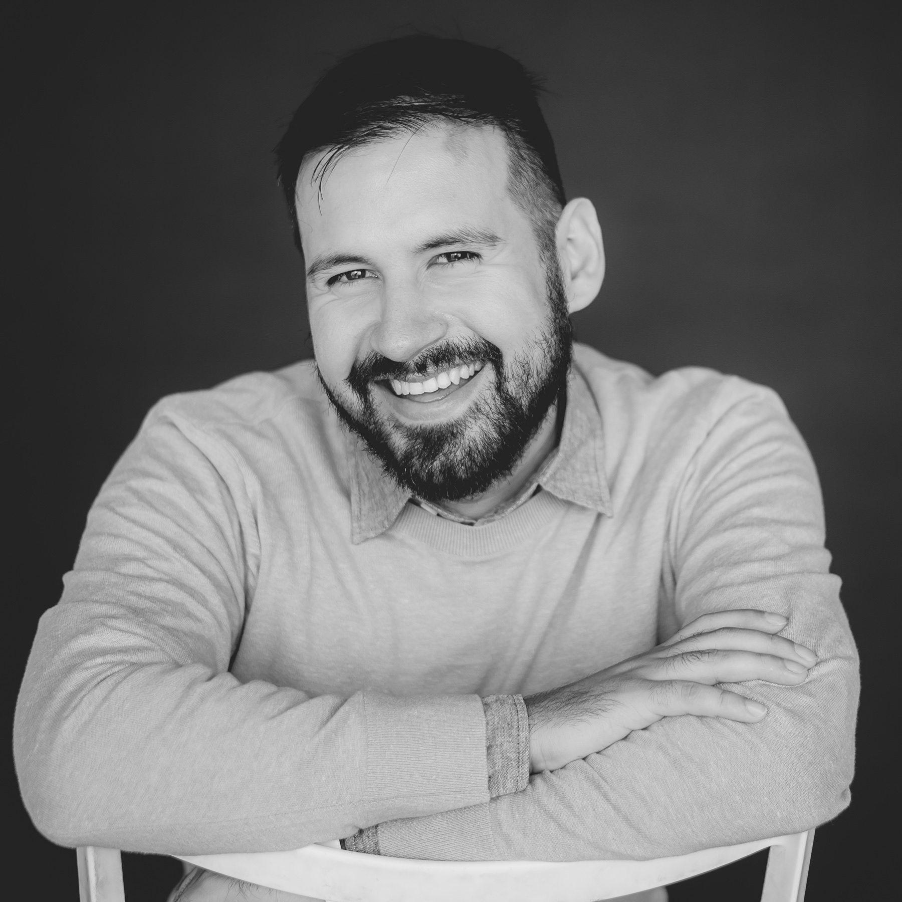 Roberto Saldana smiling in a black and white portrait